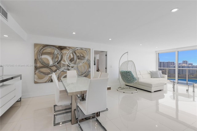 dining space featuring visible vents, baseboards, light tile patterned flooring, recessed lighting, and a view of city