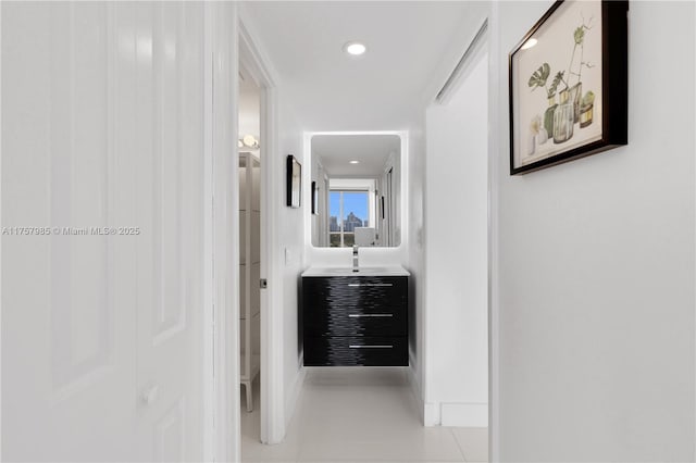 corridor with a sink, recessed lighting, and tile patterned flooring