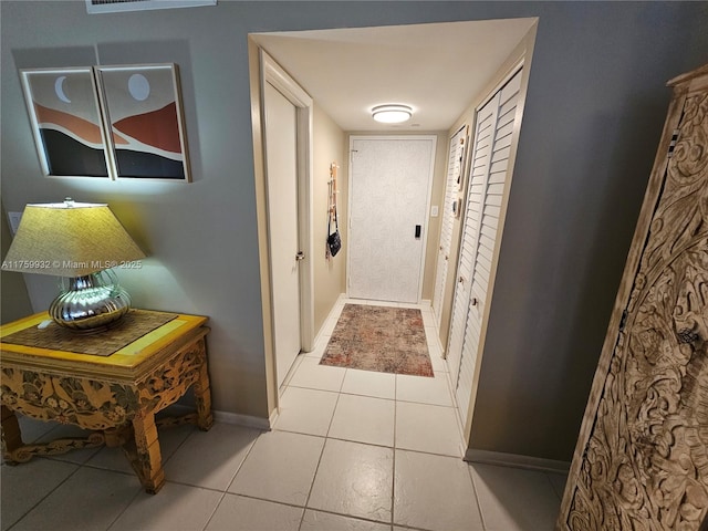 hallway with light tile patterned flooring and baseboards