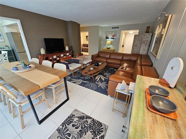 living room featuring tile patterned flooring, visible vents, and a textured ceiling