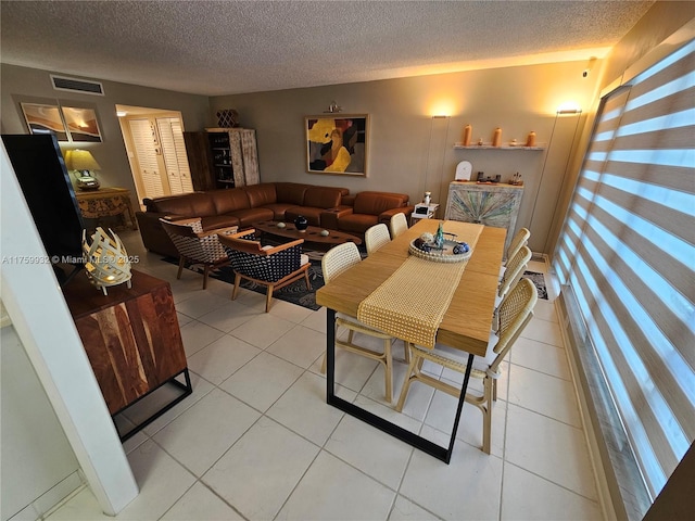 dining space with visible vents, a textured ceiling, and light tile patterned flooring