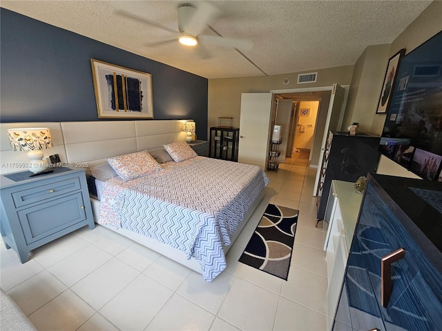 bedroom with light tile patterned floors, visible vents, a textured ceiling, and ceiling fan