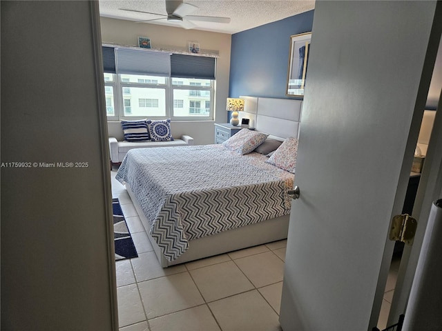 bedroom featuring light tile patterned floors, a textured ceiling, and ceiling fan