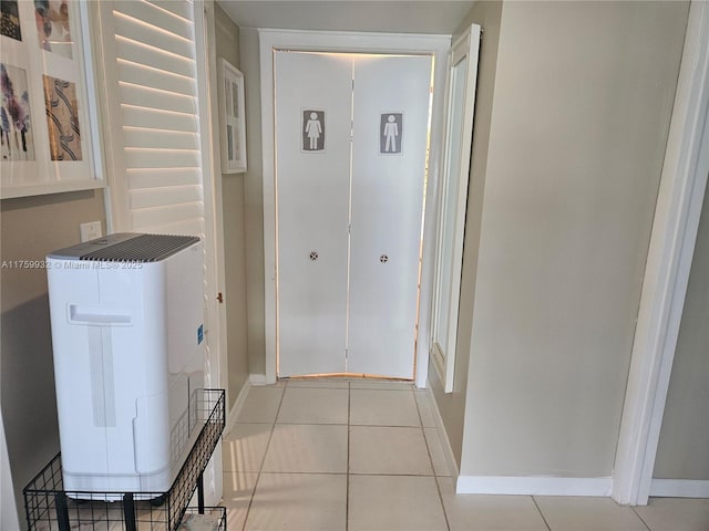 hall with light tile patterned floors and baseboards