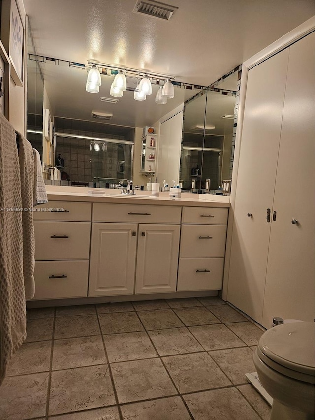 full bath featuring vanity, toilet, visible vents, and a stall shower