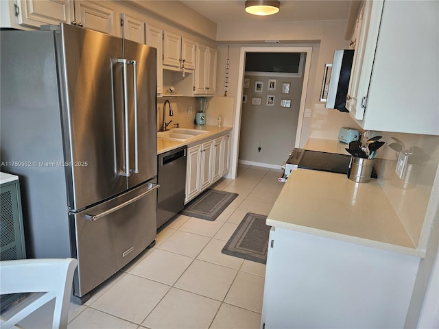 kitchen with light tile patterned floors, stainless steel appliances, light countertops, and a sink