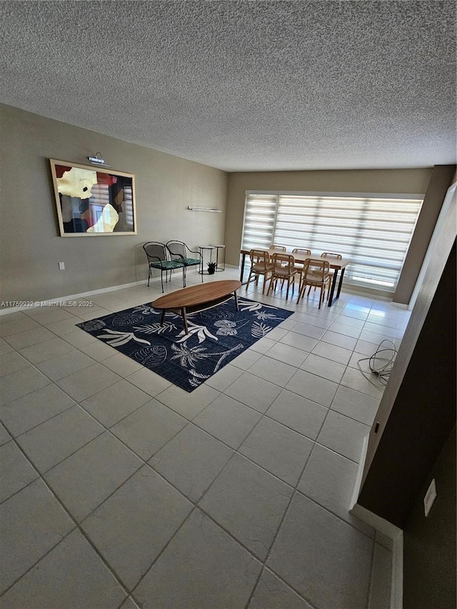 unfurnished dining area featuring baseboards, a textured ceiling, and tile patterned flooring