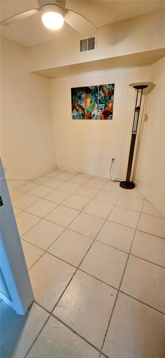 unfurnished room featuring light tile patterned flooring, visible vents, and ceiling fan