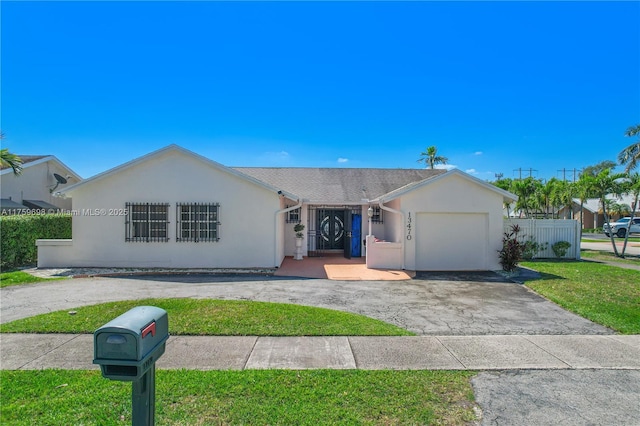 single story home with fence, a front yard, stucco siding, a garage, and driveway