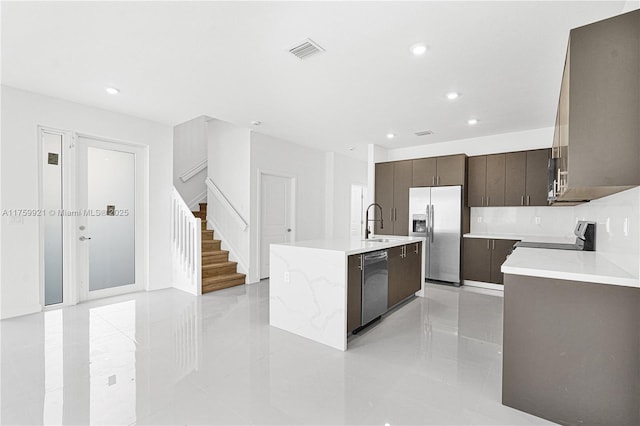 kitchen featuring visible vents, modern cabinets, a sink, stainless steel appliances, and light countertops