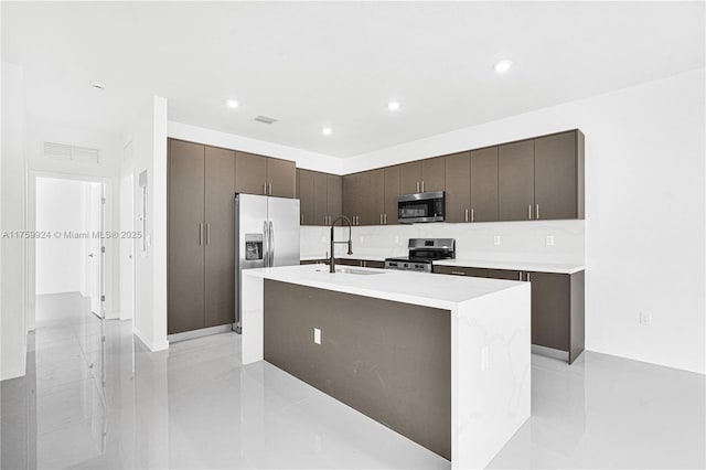 kitchen with visible vents, modern cabinets, a sink, stainless steel appliances, and dark brown cabinetry