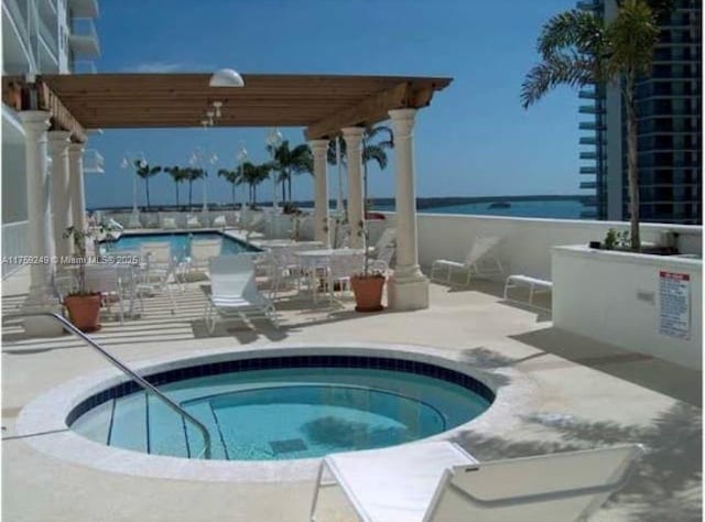 community pool with a hot tub and a patio