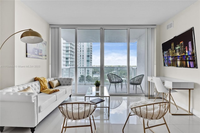 living area with visible vents, baseboards, and floor to ceiling windows