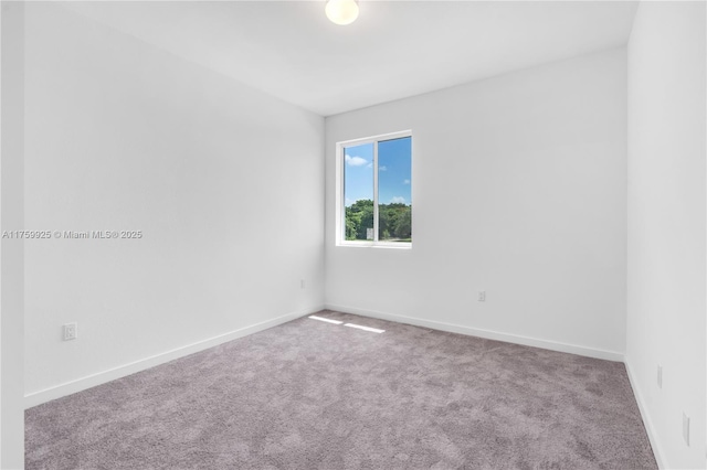 empty room featuring carpet flooring and baseboards