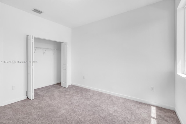 unfurnished bedroom with carpet flooring, baseboards, visible vents, and a closet