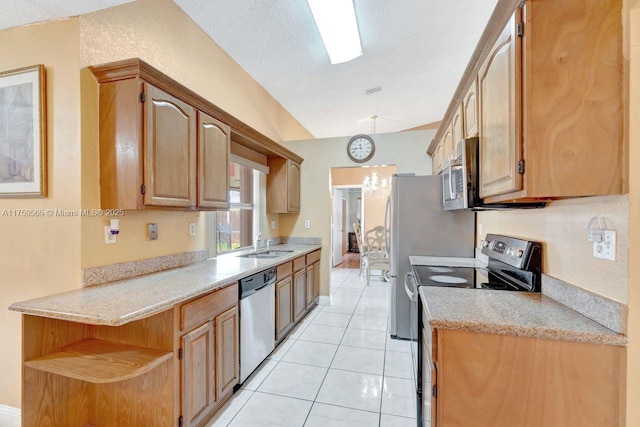 kitchen featuring a sink, a textured ceiling, light tile patterned flooring, and stainless steel appliances