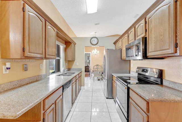 kitchen with visible vents, a sink, a textured ceiling, appliances with stainless steel finishes, and an inviting chandelier