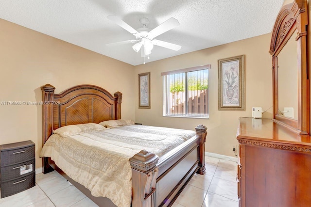 bedroom featuring light tile patterned flooring, baseboards, a textured ceiling, and ceiling fan