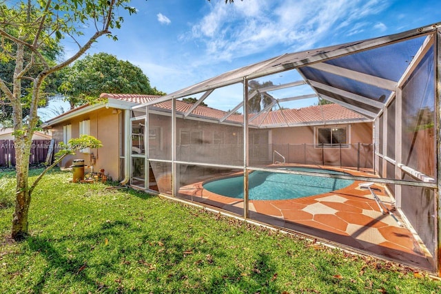 view of swimming pool featuring a lanai, a fenced in pool, a lawn, and fence