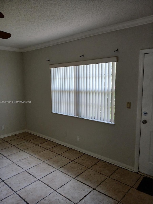 empty room with baseboards, a ceiling fan, crown molding, and a textured ceiling