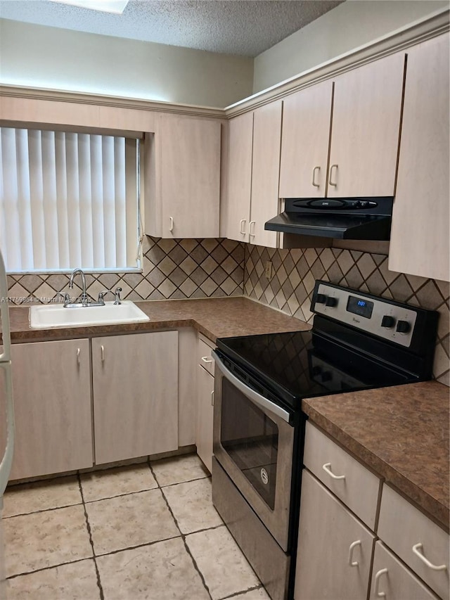 kitchen featuring a sink, stainless steel range with electric stovetop, under cabinet range hood, a textured ceiling, and tasteful backsplash