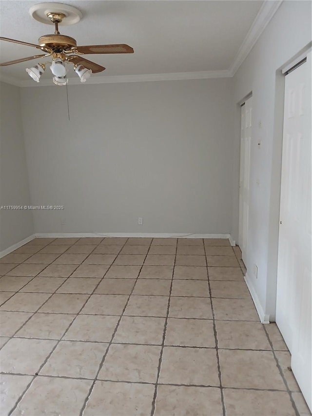 spare room featuring light tile patterned floors, baseboards, ornamental molding, and a ceiling fan