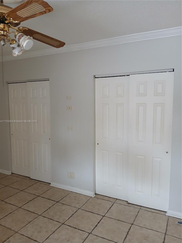 unfurnished bedroom featuring light tile patterned floors, baseboards, and crown molding