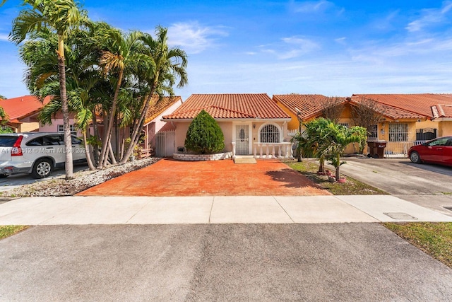 mediterranean / spanish-style house featuring concrete driveway, a tiled roof, and stucco siding