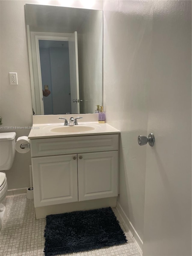 bathroom featuring tile patterned floors, baseboards, toilet, and vanity