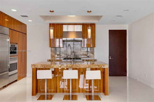 kitchen featuring decorative backsplash, a raised ceiling, modern cabinets, and visible vents