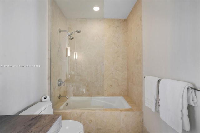 bathroom featuring toilet and tiled shower / bath combo