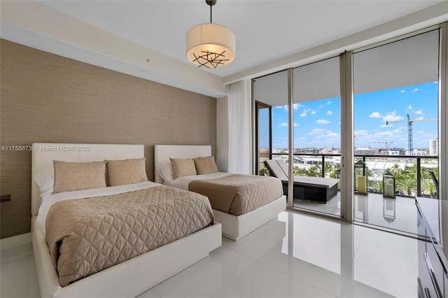 bedroom featuring access to exterior, wallpapered walls, a city view, expansive windows, and light tile patterned flooring