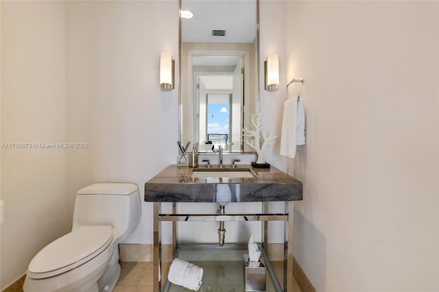 bathroom featuring a sink, visible vents, and toilet