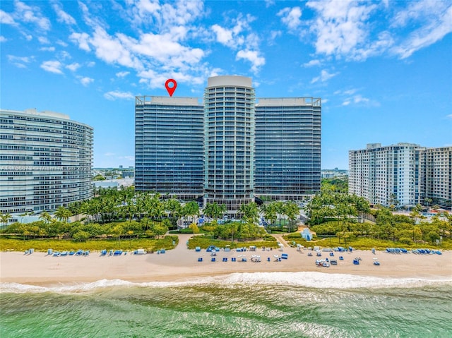 view of building exterior with a water view, a view of city, and a beach view