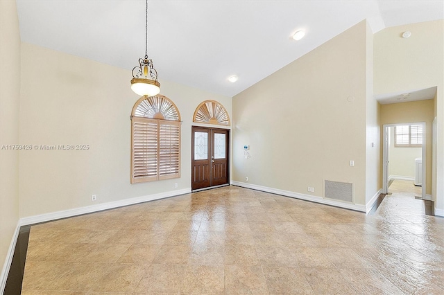 entryway with baseboards, visible vents, and high vaulted ceiling