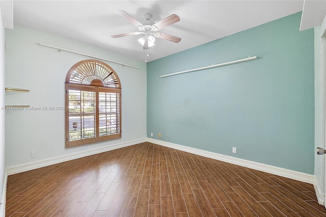 spare room featuring baseboards, a ceiling fan, and wood finished floors