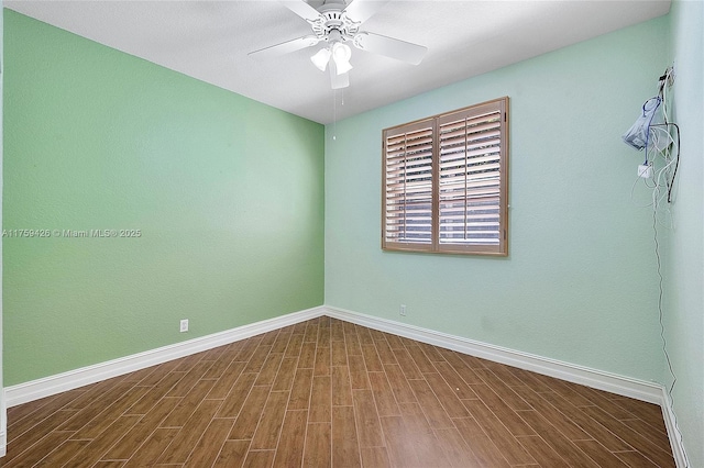 spare room featuring wood finished floors, baseboards, and ceiling fan