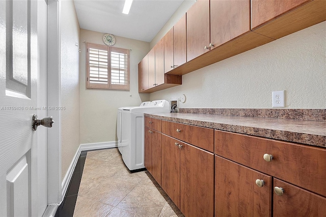 clothes washing area with separate washer and dryer, light tile patterned floors, cabinet space, and baseboards