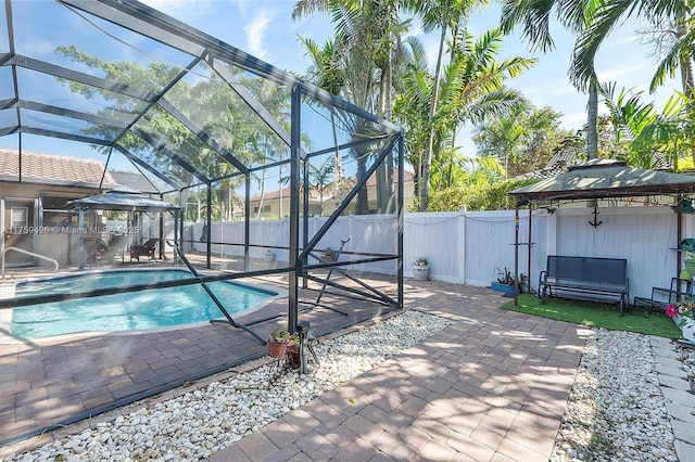 view of pool with a gazebo, a patio, a lanai, and a fenced backyard