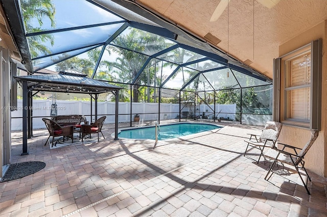 view of pool featuring glass enclosure, a fenced backyard, and a patio area