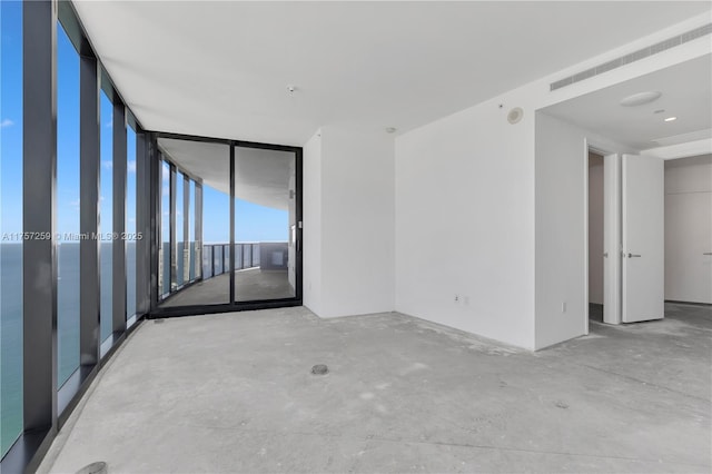 empty room with visible vents, concrete floors, and expansive windows