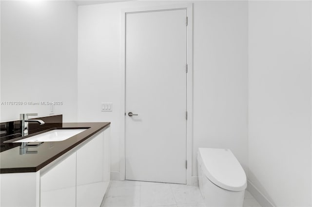 bathroom with tile patterned floors, toilet, vanity, and baseboards