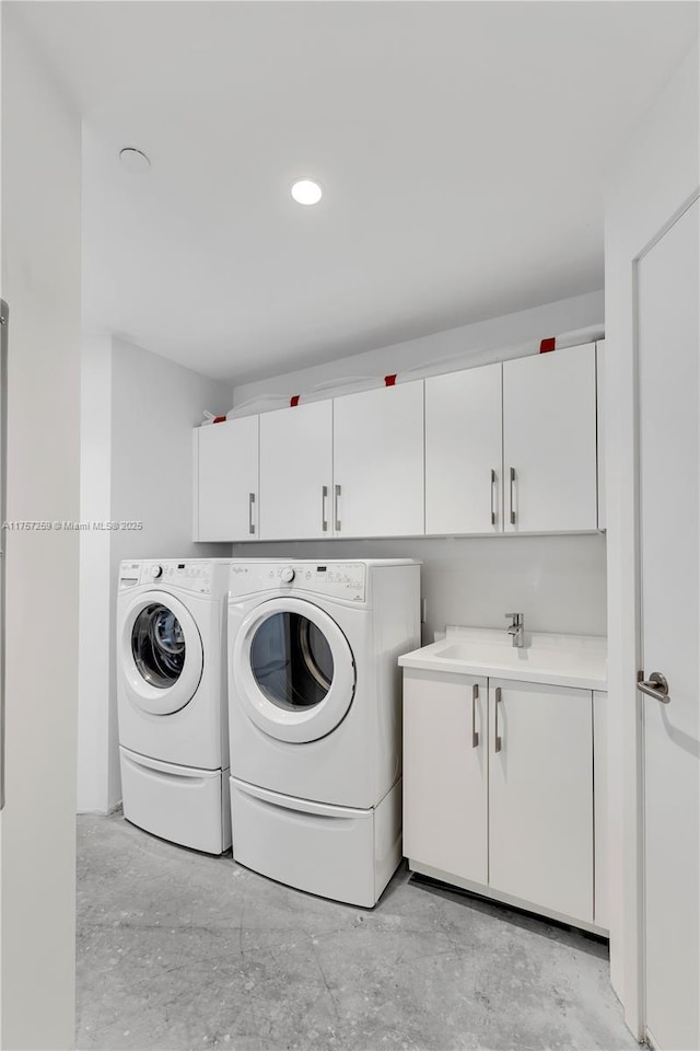 washroom featuring a sink, cabinet space, and independent washer and dryer