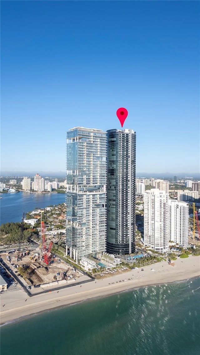 bird's eye view featuring a water view, a city view, and a beach view