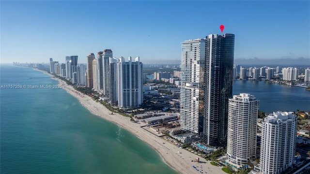 drone / aerial view featuring a view of city, a view of the beach, and a water view