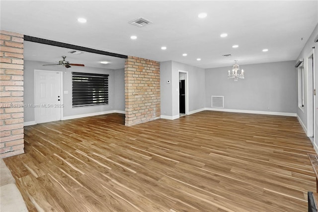 unfurnished living room with visible vents, light wood-style flooring, ceiling fan with notable chandelier, recessed lighting, and baseboards