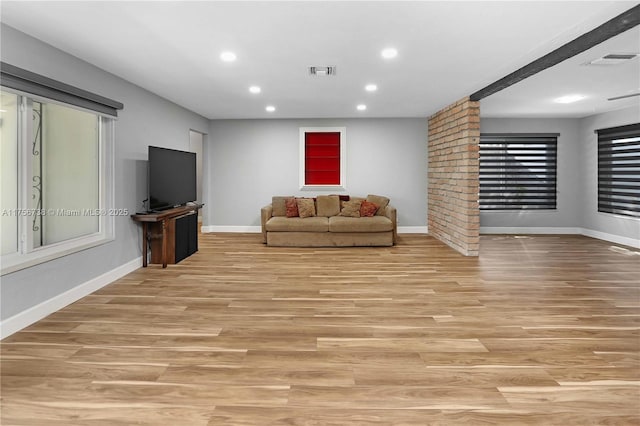 living area with baseboards, visible vents, and light wood finished floors