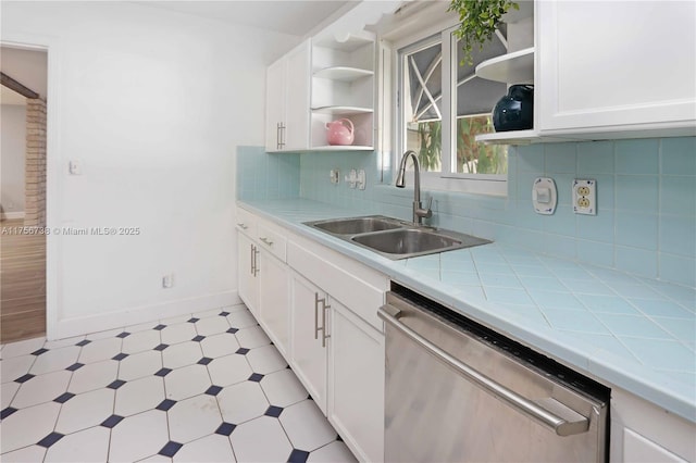 kitchen featuring open shelves, light floors, stainless steel dishwasher, white cabinetry, and a sink