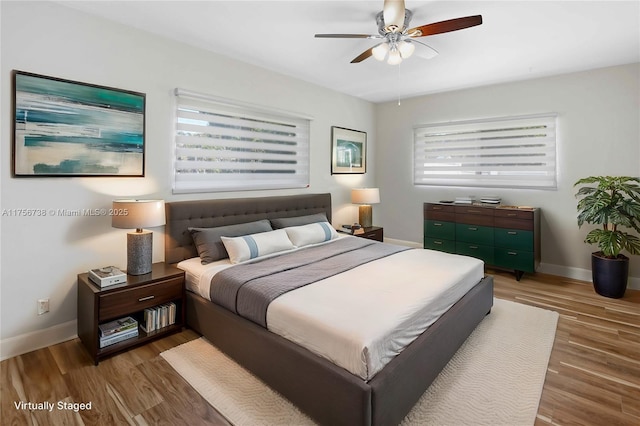 bedroom featuring a ceiling fan, wood finished floors, and baseboards