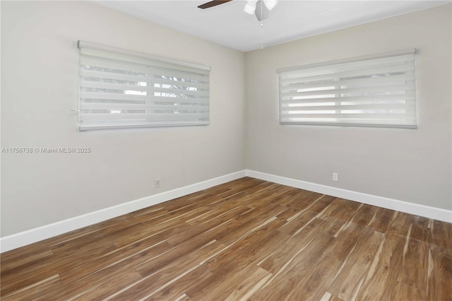 empty room with wood finished floors, baseboards, and ceiling fan